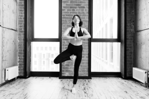 Cheerful motivated woman is standing on one leg and practising yoga — Stock Photo, Image