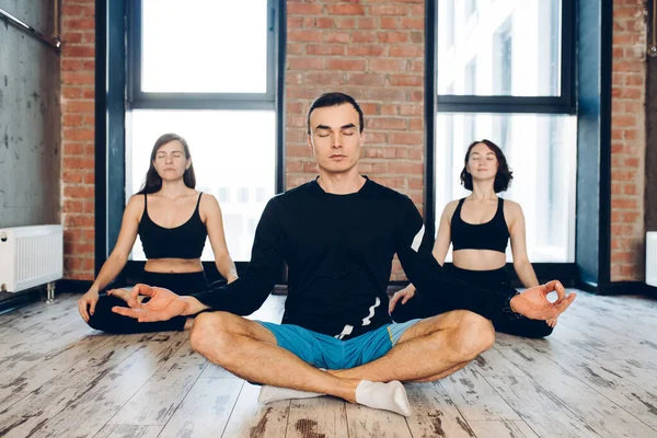 Kişisel antrenörle yoga. Formda kadınlar ve erkekler spor salonunda meditasyon yapıyorlar. — Stok fotoğraf