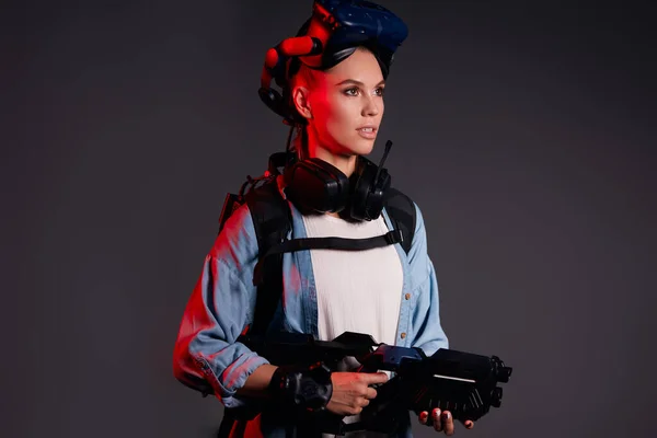 Schöne Frau mit Geräten der virtuellen Realität vor dunklem Hintergrund — Stockfoto
