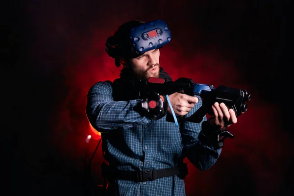 Uomo in studio per i giochi VR, dirigere la sua arma contro il nemico — Foto Stock