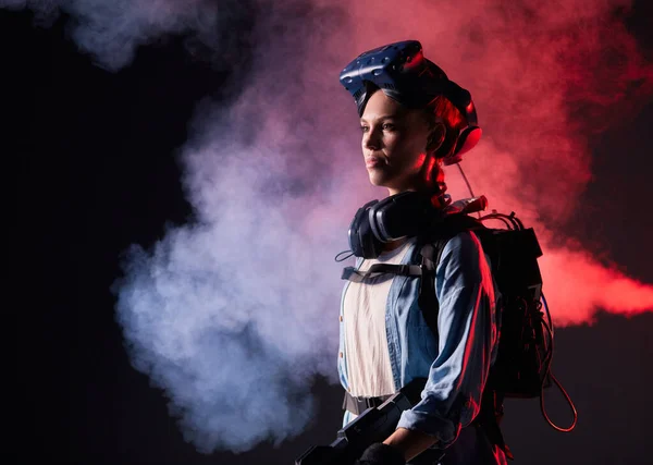 Mulher bonita em roupas futuristas sobre fundo escuro com fumaça — Fotografia de Stock