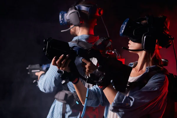 Giovane uomo e donna in abiti casual e occhiali realtà virtuale con pistole — Foto Stock
