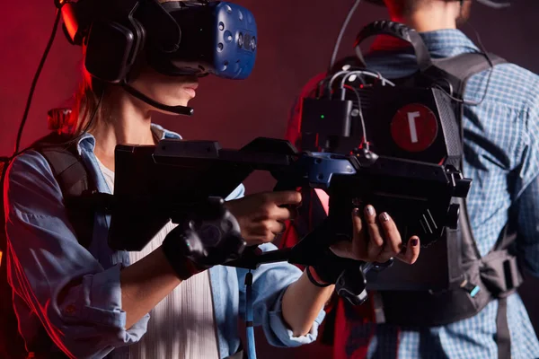 Membro della mafia femminile mirare pistola al nemico virtuale mentre indossa occhiali moderni — Foto Stock