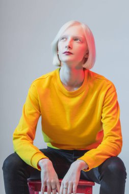 Genç ve güzel bir kadın sandalyede otururken bir şey düşünüyor.