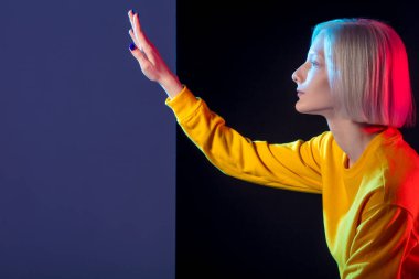 Güzel, sarışın kız havaya dokunuyor.