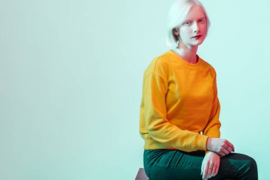 Şehvetli kız sandalyede oturuyor ve kameraya bakıyor.