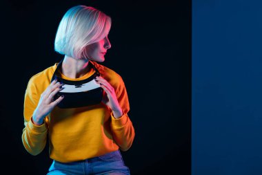 Güzel, genç, sarışın bir kadın yana bakıyor.