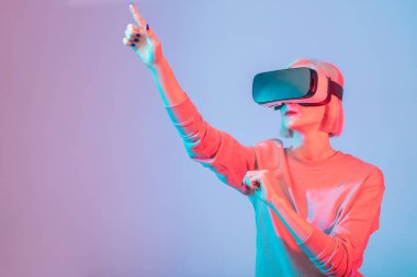 Genç bir kadın gözlük takarken el kol hareketi yapıyor.