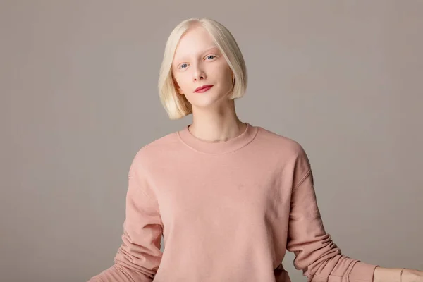 Smiling attractive girl in pink stylish sweater — Stock Photo, Image