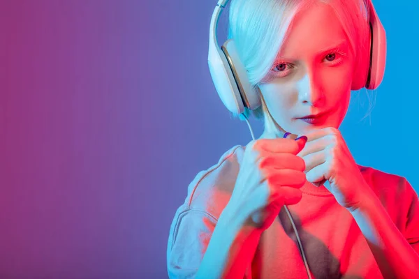 Chica con una piel pálida usando auriculares y practicando boxeo. —  Fotos de Stock