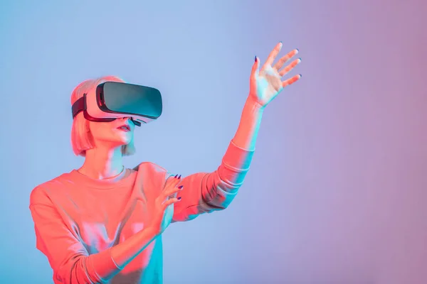 Chica atractiva tocando el aire durante la experiencia VR — Foto de Stock