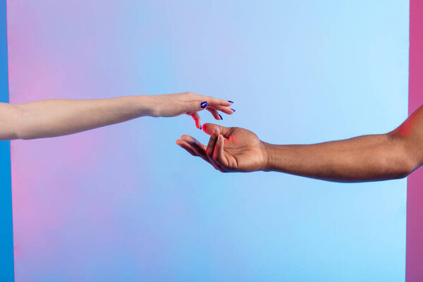 Кавказская девушка и афроамериканец крепко держатся за руки