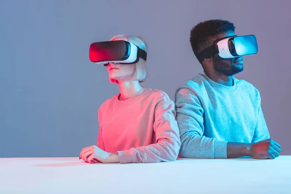 Jonge internationale mensen aan tafel met VR-brillen — Stockfoto
