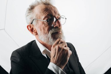 Beyaz arka planda siyah takım elbiseli yakışıklı yaşlı CEO portresi.