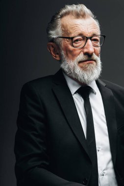 Siyah takım elbiseli, esmer arka planda yakışıklı yaşlı CEO portresi.