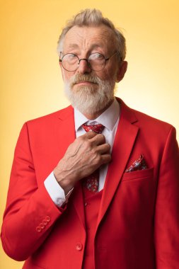 Son sınıf utangaç yetenekli müzisyen yorgun üzgün gözleriyle kırmızı elbisesiyle sarı üzerine poz veriyor.