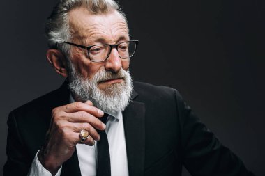 Siyah takım elbiseli, kendine güveni tam yaşlı bir adam.