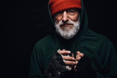 Yaşlı dilenci dışarıda donuyor, ısınmak için sıcak su içiyor. Evsiz.