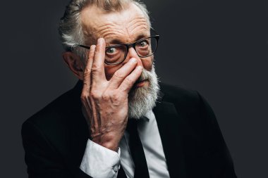 Siyah takım elbiseli, esmer arka planda yakışıklı yaşlı CEO portresi.