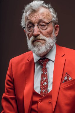 Olgun müzisyen yorgun üzgün gözlerle siyah üzerine kırmızı bir elbise giymiş.