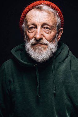 Kırışıklıkları olan, sıcacık, pejmürde giysileri olan tecrübeli yaşlı bir adam.