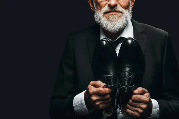 Anciano barbudo en traje elegante que muestra zapatos de cuero hechos a medida — Foto de Stock