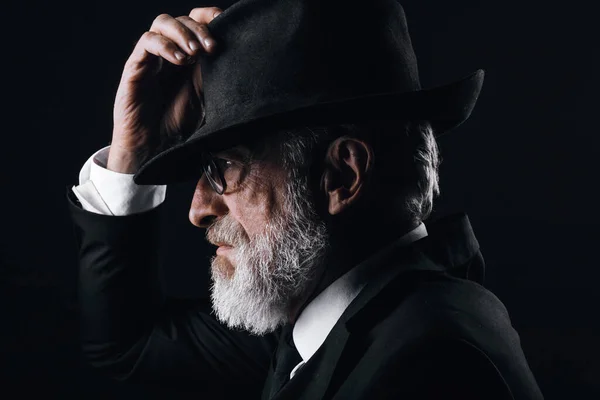 Fötr şapkanın arkasına saklanan, İngiliz casusu rolünü oynayan yaşlı bir erkek oyuncu.. — Stok fotoğraf