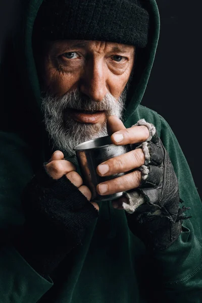 Elderly beggar being frozen outside, drinking hot water to get warm. Homeless. — Stock Photo, Image