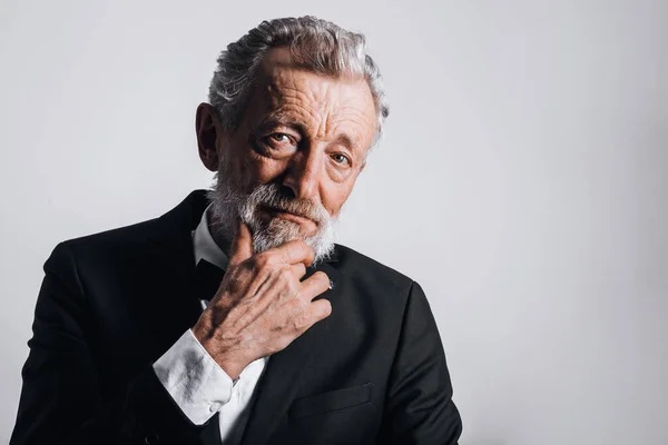 Close-up portret van zelfverzekerde volwassen man in smoking geïsoleerd op zwarte achtergrond — Stockfoto