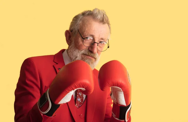 Starší obchodník v červené nosí boxerské rukavice stojící v obranné pozici — Stock fotografie