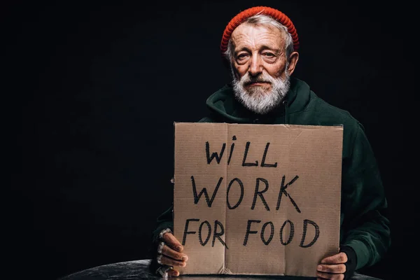 Senza lavoro vecchio mendicante in possesso di un segno scritto a mano per aiuto e denaro. — Foto Stock