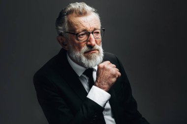 Siyah takım elbiseli, esmer arka planda yakışıklı yaşlı CEO portresi.