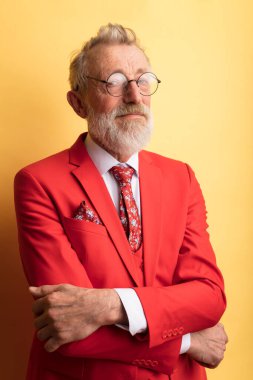 Başarılı bir moda tasarımcısı. Şık, kırmızı bir elbise ve boyunbağı var.