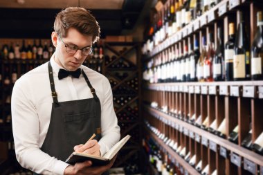 Sommelier, mahzendeki şarap ürünleri hakkında bilgi içeren notlar yazar.