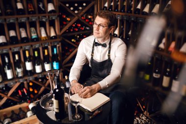 Şarap tadımcısı not defterine şarap menşei ve tadı hakkında bilgi yazmış..