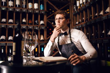 Dalmış alkol eleştirmeni dikkatle şaraba bakıyor.