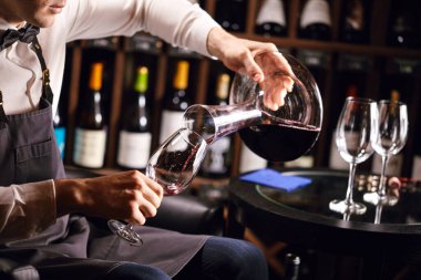 Uzman sürahisi ve bardağa şarap dökme. Sommelier için personel eğitimi