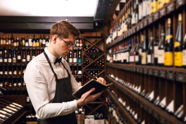 Sommelier şarap dükkanına şarap ürünleri hakkında bilgi bırakıyor.