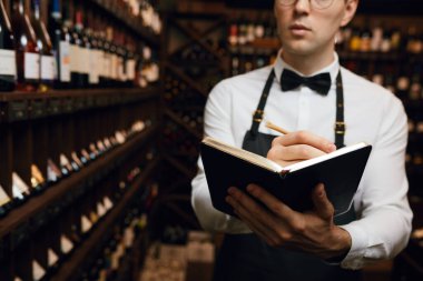 Sommelier, mahzendeki şarap ürünleri hakkında bilgi içeren notlar yazar.