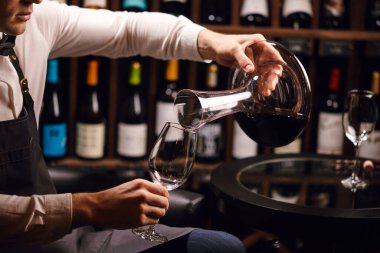 Uzman sürahisi ve bardağa şarap dökme. Sommelier için personel eğitimi