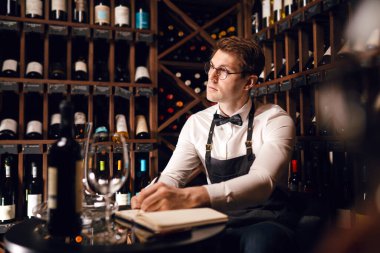Sommelier, mahzendeki şarap ürünleri hakkında bilgi içeren notlar yazar.