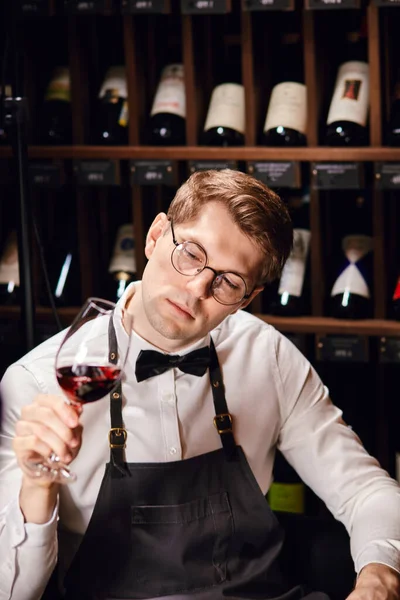 Кавіст шукає спеціальне вінтажне або конкретне вино для клієнта у винному магазині — стокове фото