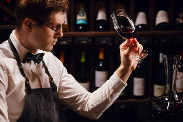 Weinexperte hält ein Glas Wein in der Hand, blickt auf Tönung und riecht Aroma — Stockfoto