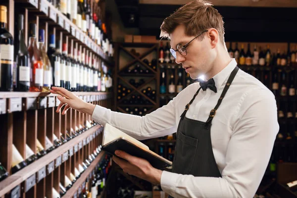 Sommelier şarap dükkanındaki şarap ürünleri hakkında bilgi yazıyor. — Stok fotoğraf