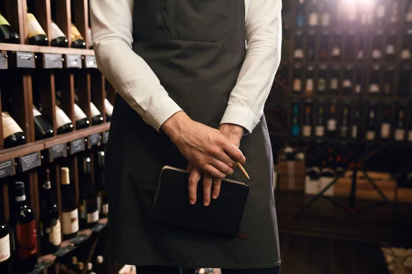 Sommelier schrijft op briefjes, zet informatie over wijnproducten in de kelder — Stockfoto