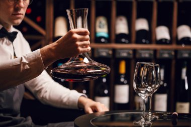 Uzman sürahisi ve bardağa şarap dökme. Sommelier için personel eğitimi