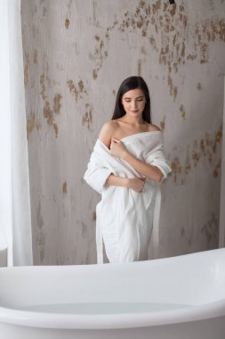 Bornozla poz veren güzel esmer kadın.