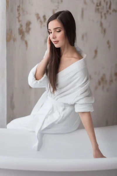 Mooie jonge vrouw poseren in badjas voor het nemen van bad — Stockfoto
