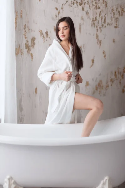 Belle jeune femme posant en peignoir avant de prendre un bain — Photo