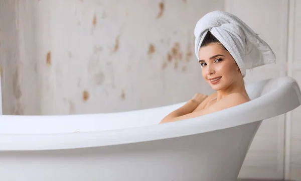 Entspannte junge Frau liegt in Badewanne — Stockfoto